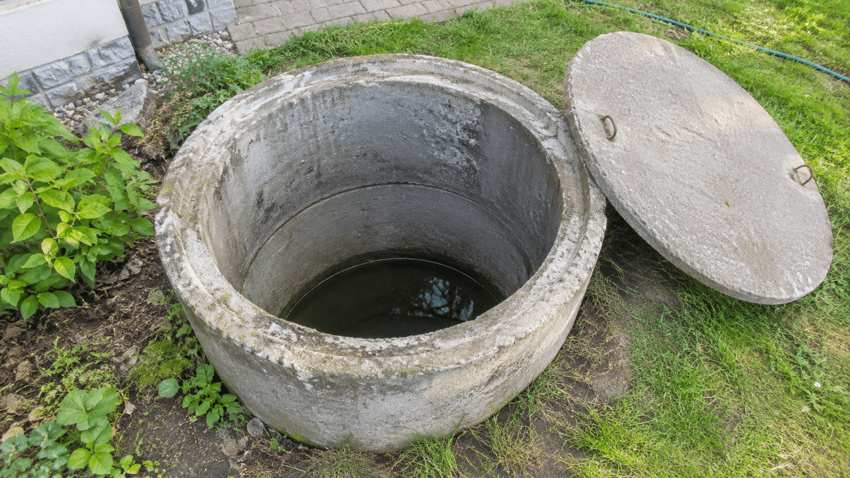 Otevřená kopaná studna z betonových skruží s víkem vedle